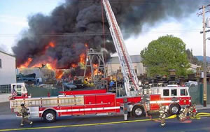 photo of County fire truck and firefighters putting out a fire